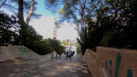 A man carries a stroller with children down a few narrow stairs in the mall Stock Footage 122171390