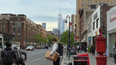 Man carrying Amazon box walking across street package Freedom Tower New York NYC 库存影片 107343561