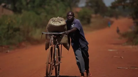 Man carrying a big sack with his bike Stock Footage 148748545
