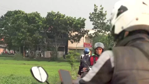 Man Carrying Bird Cage Walks Along Rural Indonesian Road with Scooter Traffic Stock Footage 343883684