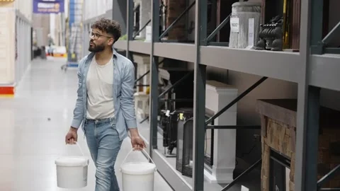 Man carrying buckets walking in hardware store Stock Footage 336965115