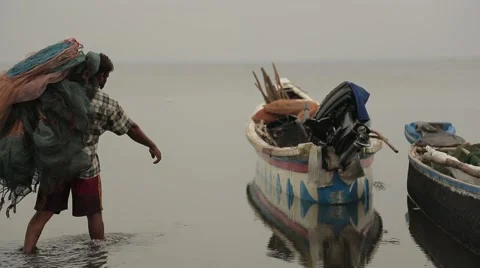 Man carrying fish nets to a boat in Sri Lanka Stock Footage 49365719