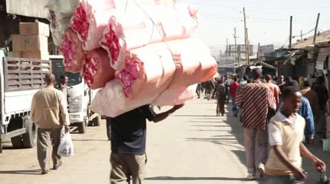 Man carrying high bundle of goods in open air market,  Addis Ababa,  Africa Stock Footage 22149321