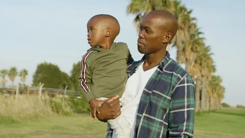 Man carrying his son walking in park Stock Footage 119618148