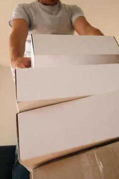 Man Carrying Stack of Moving Boxes Stock Photos