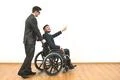 The man carrying a wheelchair with a disabled on the white wall background Photo