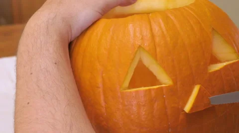 Man Carves a Nose in a Pumpkin to make a Jack 'o' Lantern Stock Footage 68766513
