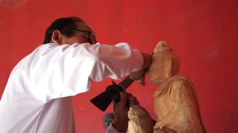 Man carves a statue of Buddha made of wood Stock Footage 70262196