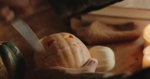 Man carving a pumpkin in a moody table  Stock Footage 141909086