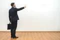 The man with a case gesturing on the white wall background Photo