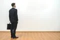 The man with a case standing on the white wall background Photo
