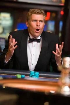 Man in casino playing roulette and losing (selective focus) Stock Photos