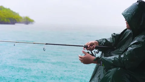 A man casting a line under the line. Peaceful Fishing on a Wet Day. Fishing.. Stock Footage 304094591
