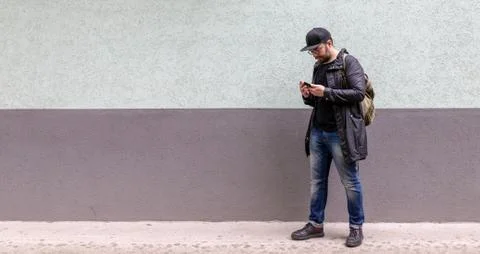 A man with a casual backpack close to wall Stock Photos