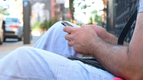 A man in a casual clothes is texting some message using a smartphone. Video stock 62528966