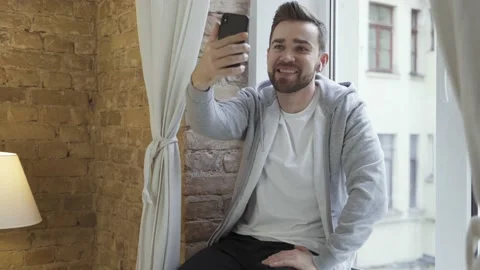 Man in casual clothes using phone and having video call Video stock 233432977