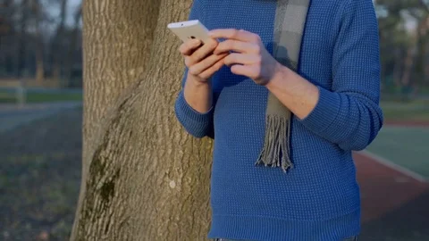 Man in casual, warm clothes browsing internet on smartphone, steadycam shot Stock-Footage 70755897