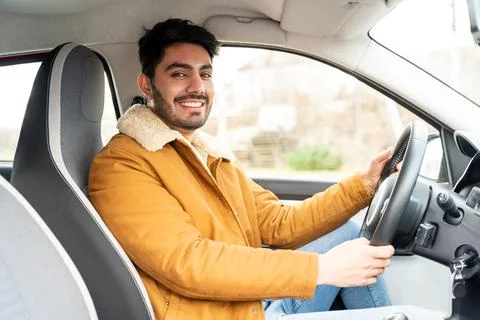 Man casually dressed with hands holding driving wheel riding car at daytime Stock Photos