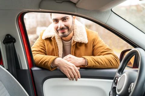 Man casually dressed with hands holding driving wheel riding car at daytime Stock Photos