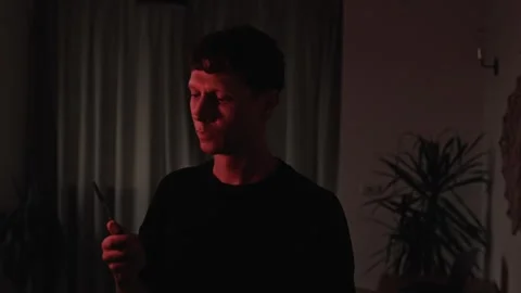 Man casually tossing and catching a knife while contemplating a dangerous plan Stockbeeldmateriaal 347300512
