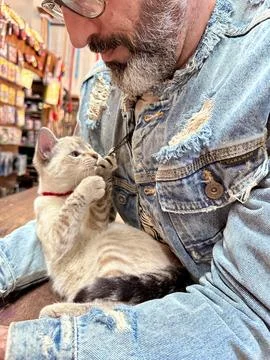 Man with cat in denim jacket Stock Photos