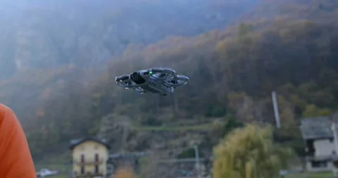 Man catches a compact drone landing on his hand in a mountain valley. Close-up Stock Footage 345021838
