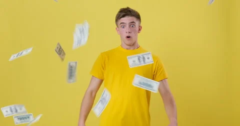 Man catches falling bills over yellow background 库存影片 144957020