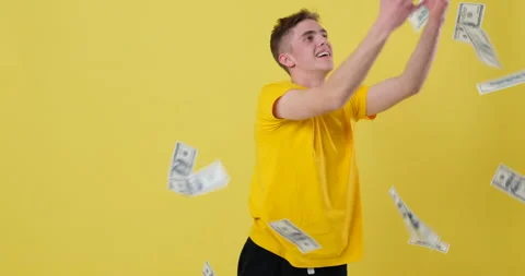 Man catches falling bills over yellow background Stock Footage 144958506