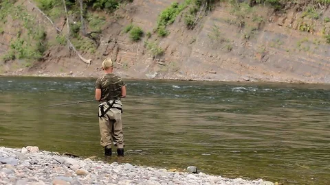 Man catches fish in the river. man fishing with a rod and reel. Stock Footage 78527499
