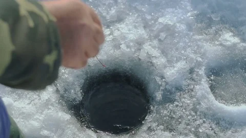 Man catches fish on winter Lake Stock Footage