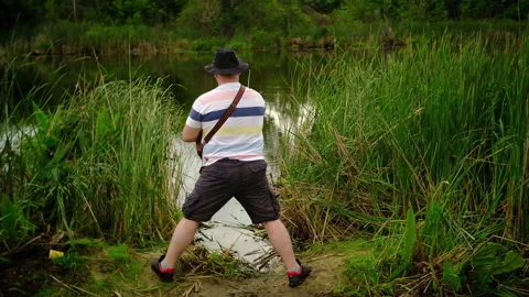 A man catches a predatory fish on the river bank, swamps, on spinning Stock-Footage 135429989