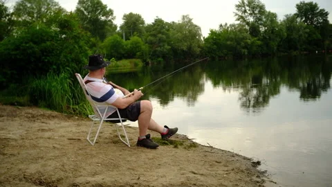 A man catches a predatory fish on the river bank, swamps, on spinning Stock-Footage 135430090