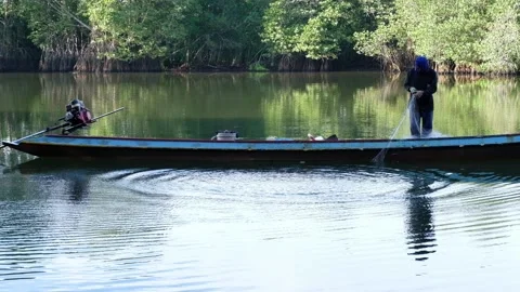 A man catching fish in a calm river Video stock 134791440