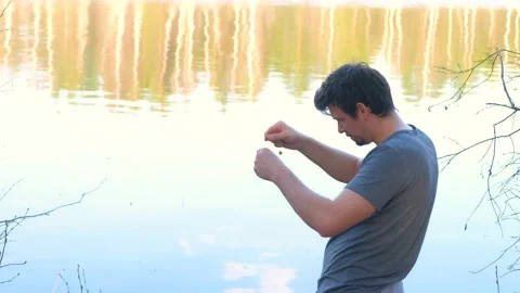 Man is catching a fish in river using a fishing rod at sunset, side view. Stock Footage 136423298