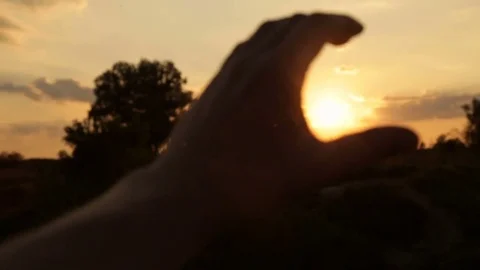 The man is catching the sunset by the hand Stock Footage 77617001