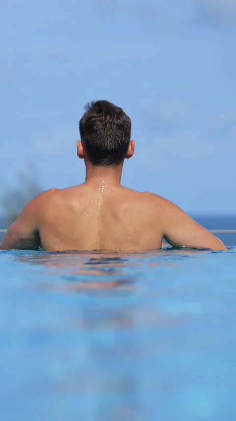 Man Caucasian In Infinity Pool Ocean View, Solo Traveler Leans On Pool Edge, Sun Vídeos de archivo 332871617