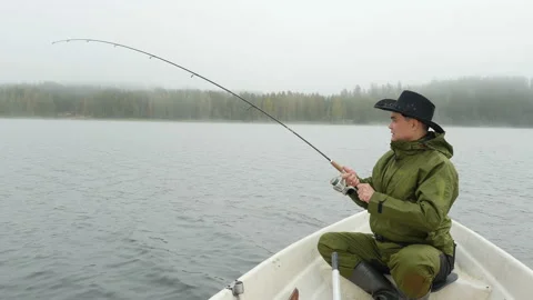 A man caught big fish with reel rod from boat on lake Stock Footage 97597257