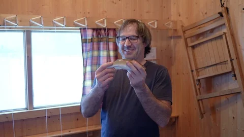 Man With Caught Fish in Hands Inside Ice Fishing Shack Stock Footage 102609997