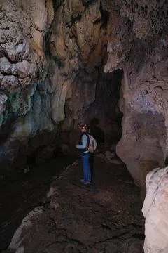 Man in a cave with a flashlight on his head Foto stock