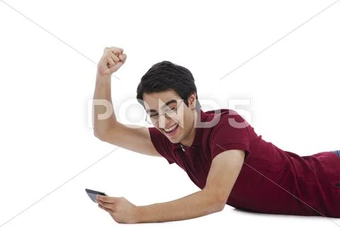 Man celebrating his success while playing game on a mobile phone Stock Photos