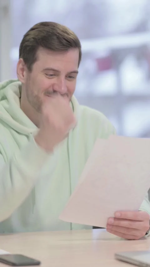 Man Celebrating Success while Reading Documents in Office, vertical video Vidéo 329105136