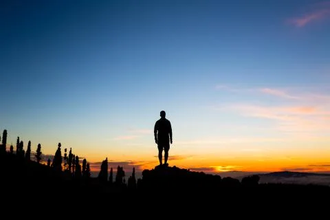 Man celebrating sunset looking at view in mountains Stock-Fotos