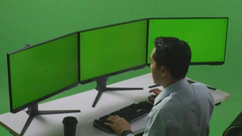 Man Celebrating While Working With Mock Up Multiple Computer Monitor In Green Stock Footage 249634177