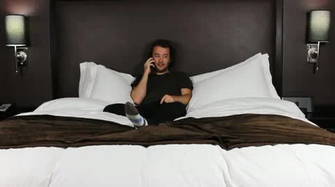 Man on cell phone in bed - HD Stock Footage 12236321