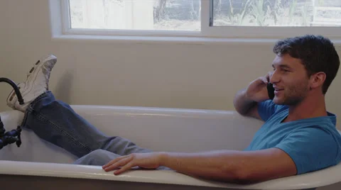 Man on Cell Phone in Empty Bath Tub Stock Footage 35293550