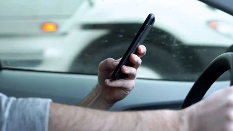 Man with cell phone texting while driving in snow Vídeos de archivo 123985202