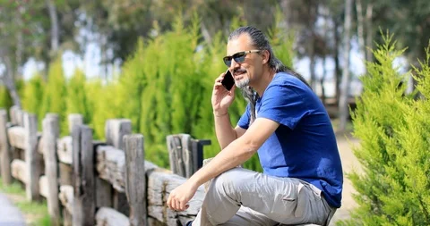 Man with cellphone at the green nature Stock Footage 105478142