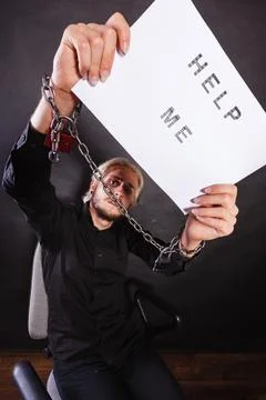Man with chained hands holding help me sign Stock Photos