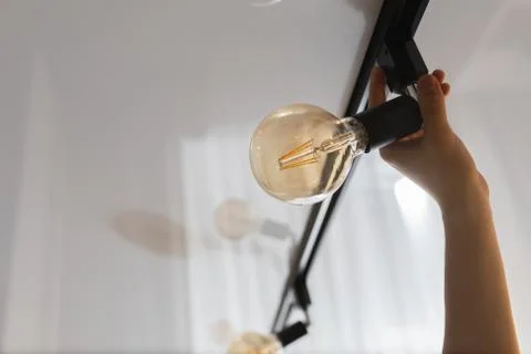 A man changes a burnt out light bulb at home Stock Photos