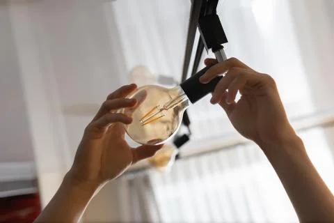 A man changes a burnt out light bulb at home Stock Photos